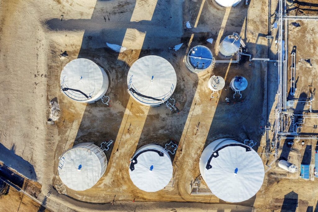 Drone shot of industrial storage tanks in Eyota, Minnesota, showcasing large equipment and intricate shadows.
